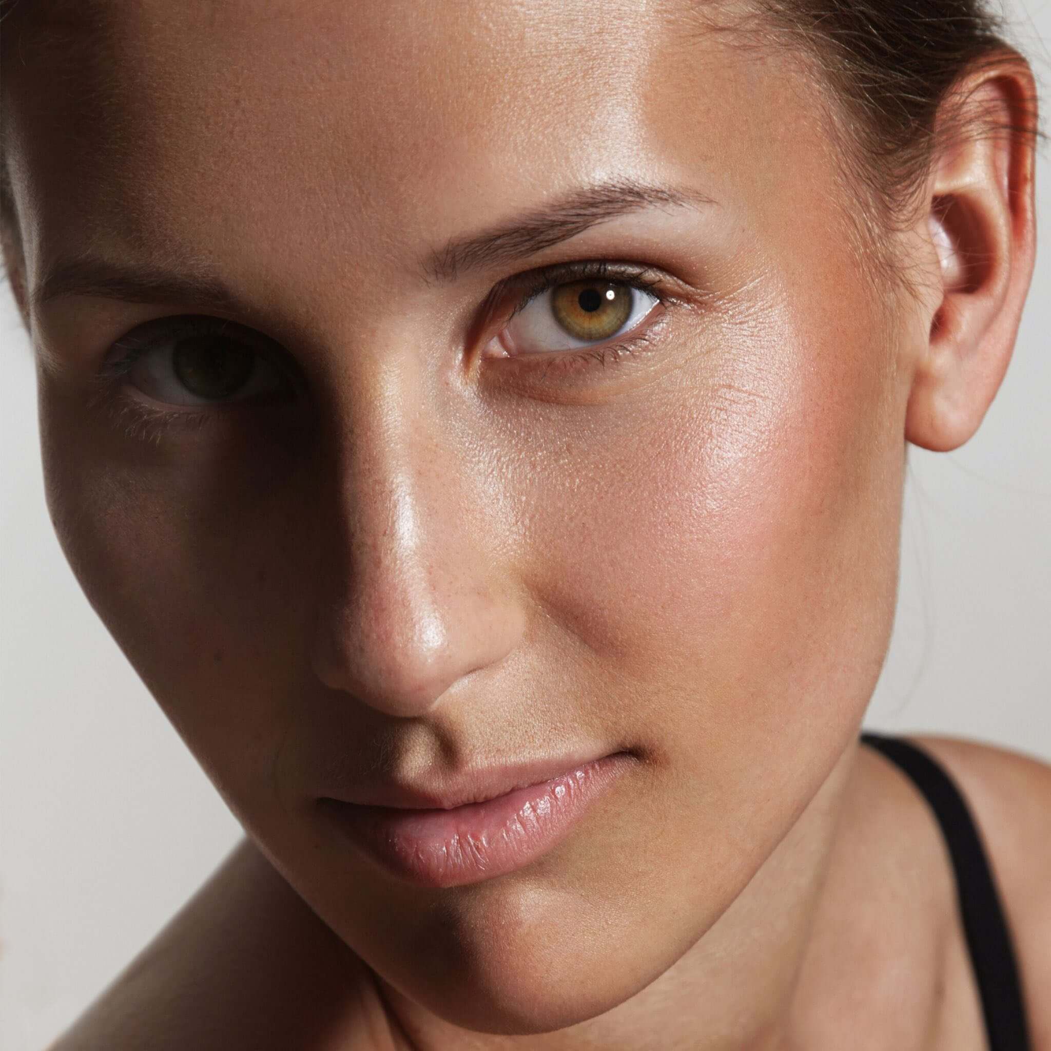 Close-up of a woman's face showcasing natural beauty and radiant skin with captivating eyes.
